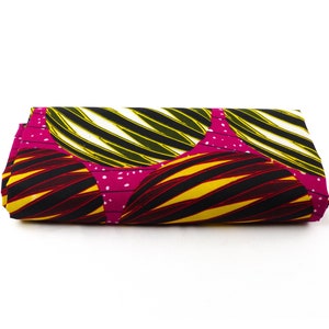 May include: A folded piece of fabric with a colourful geometric pattern. The fabric is black, yellow, white, and pink with a striped design.