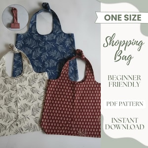 May include: Three fabric shopping bags with leaf and floral patterns in cream, navy blue, and burgundy. The bags have knotted handles. The image also includes a small, matching bag and text that reads "ONE SIZE" and "Shopping Bag".