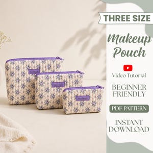 Può includere: Tre pochette per il trucco trapuntate di diverse dimensioni, con sfondo color crema, motivo floreale viola, cerniere viola e una piccola etichetta rettangolare con la scritta handmade. Il testo a destra recita THREE SIZE Makeup Pouch.