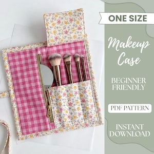Pode incluir: Uma nécessaire de maquilhagem feita à mão com interior em rosa xadrez e detalhes florais. A nécessaire contém pincéis de maquilhagem e um espelho. O texto na imagem diz "ONE SIZE", "Makeup Case", "BEGINNER FRIENDLY", "PDF PATTERN" e "INSTANT DOWNLOAD".