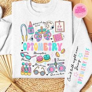 May include: A light gray sweatshirt with a colorful Optometry design. The design includes illustrations of eye care tools, glasses, and the word "OPTOMETRY" in pastel colors. The right sleeve has the text "Can't talk right now Doing OPTOMETRY STUFF".