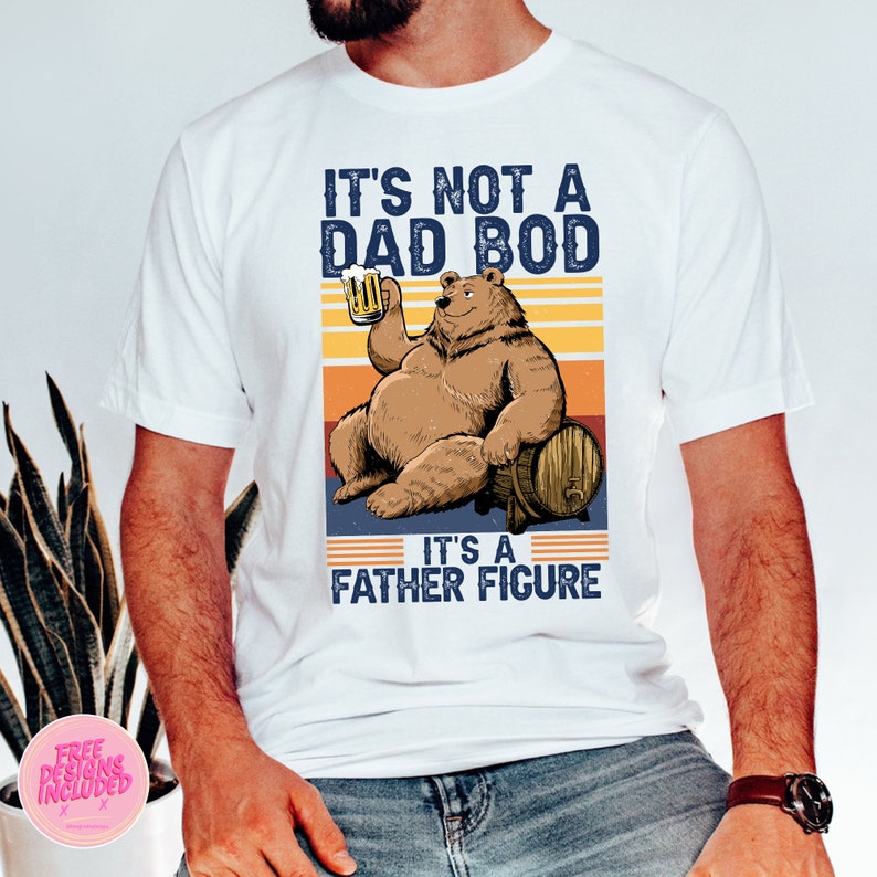 May include: White t-shirt with a retro-style graphic of a bear holding a beer and the text "It's not a dad bod, it's a father figure."