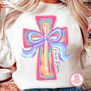 May include: A white sweatshirt with a colorful cross design and the text "He is Risen" printed on the front.