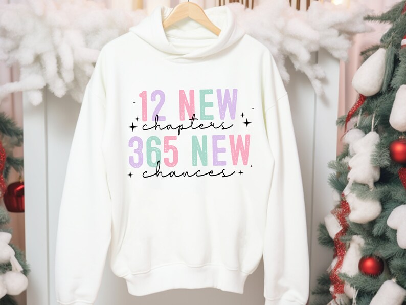 May include: White hoodie with a pink, purple, and green graphic print that says "12 NEW chapters + 365 NEW chances +"