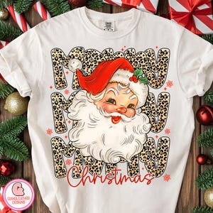 Puede incluir: Camiseta blanca con un dise&ntilde;o de Pap&aacute; Noel con gorro rojo y barba blanca. Las palabras "Merry Christmas" est&aacute;n impresas en la camiseta con una fuente de estampado de leopardo. Ropa festiva navide&ntilde;a.