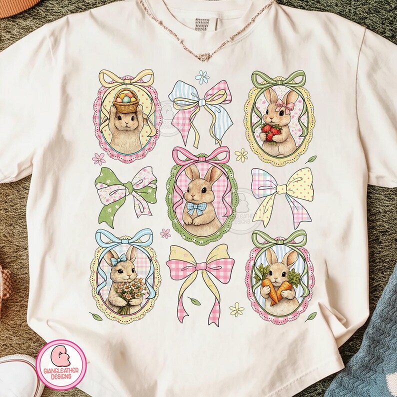 K&ouml;nnte beinhalten: Cremefarbenes T-Shirt mit neun Ostermotiven. Die Designs umfassen ovale Rahmen mit Hasen, die Osterk&ouml;rbe, Blumen und Karotten halten, sowie bunte Schleifen. Das Shirt hat unten den Text "GIANGLEATHER DESIGNS".