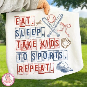May include: White baseball-themed towel with the words "EAT. SLEEP. TAKE KIDS TO SPORTS. REPEAT!" in red and blue block letters. Includes illustrations of baseball bats, a ball, a glove, and a cap.
