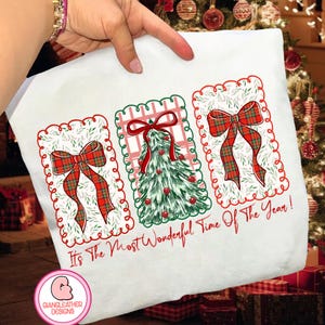 May include: White Christmas-themed fabric with three rectangular designs. Each design features a red plaid bow or a decorated Christmas tree. The text "It's The Most Wonderful Time Of The Year!" is written in red cursive.