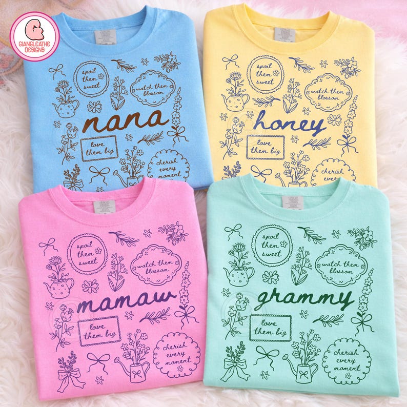 May include: Four crew neck sweatshirts in pastel colors: blue, yellow, pink, and mint green. Each shirt features a floral design with the words "nana", "honey", "mamaw", and "grammy" in a script font. The design includes the phrases "spoil them sweet", "watch them blossom", "love them big", and "cherish every moment".