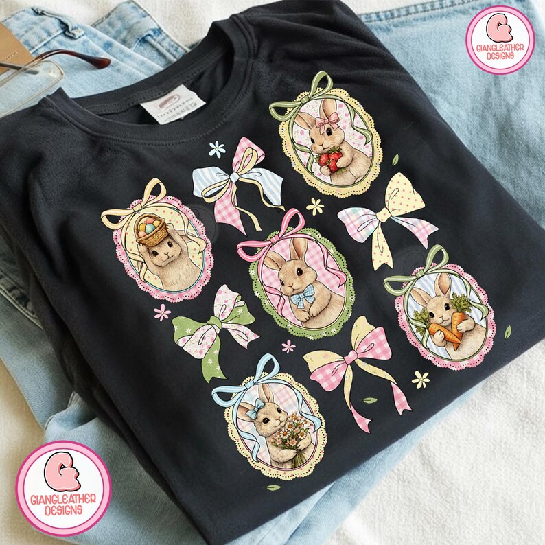 K&ouml;nnte beinhalten: Schwarzes T-Shirt mit ovalen Portr&auml;ts von Hasen, die Karotten, Blumen und Ostereier halten. Pastellfarbene Schleifen und florale Akzente umgeben die Portr&auml;ts. Das T-Shirt tr&auml;gt den Text "GIANGLEATHER DESIGNS".