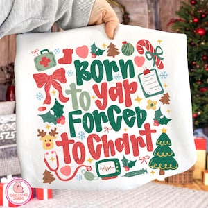 May include: White Christmas-themed tote bag with the text "Born to Yap, Forced to Chart" in green and red. The design includes medical symbols, snowflakes, and festive illustrations like a Christmas tree, reindeer, and candy cane.