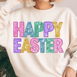 Könnte beinhalten: Ein weißer Pullover mit den Worten "Frohe Ostern" in bunten Glitzerbuchstaben.
