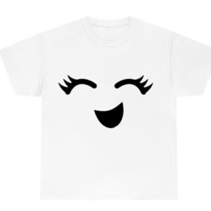 May include: White t-shirt with a black smiling face with eyelashes.