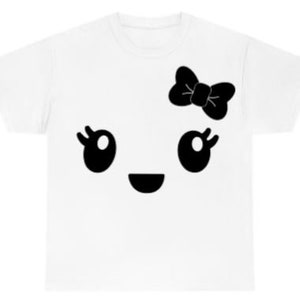 May include: White t-shirt with a black cartoon face with big eyes, a smile, and a bow on top.