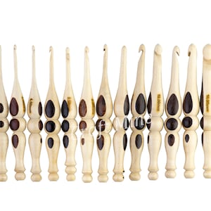 Op de afbeelding: Set van 10 haaknaalden van hout met bruine en beige accenten. De haaknaalden zijn gemarkeerd met hun maat in millimeters: 3,50 mm, 4,00 mm, 4,50 mm, 5,00 mm, 5,50 mm, 6,00 mm, 7,00 mm, 8,00 mm, 10,00 mm en 16,00 mm.