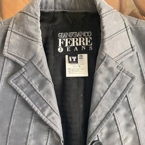 Peut inclure: Veste Gianfranco Ferre Jeans gris clair avec des coutures noires. Elle présente un col cranté, une fermeture à un bouton et une doublure noire. L'étiquette indique "GIANFRANCO FERRE JEANS" et "ITALY".