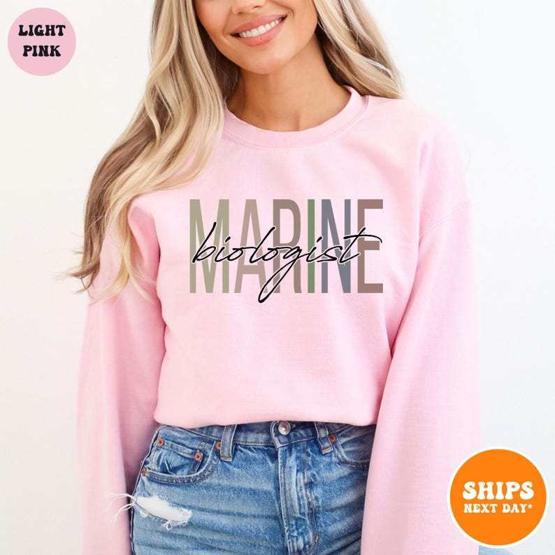 a woman wearing a pink sweatshirt with the words marine on it