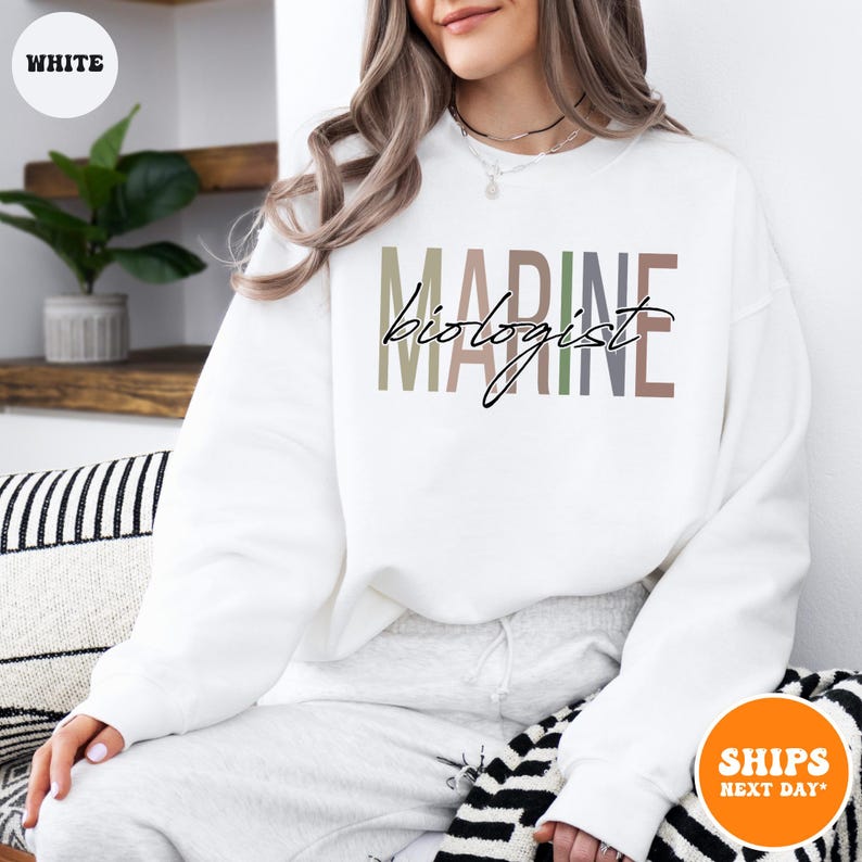 a woman sitting on a couch wearing a white sweatshirt