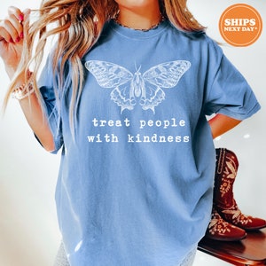 a woman wearing a blue shirt with a butterfly on it