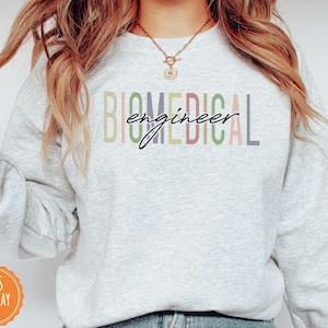 May include: A light gray sweatshirt with the text "Biomedical engineer" in rainbow colors.