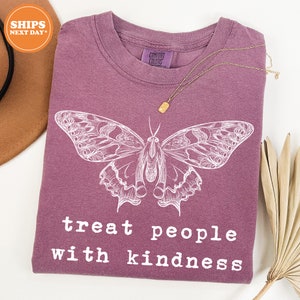 a purple shirt with a butterfly on it