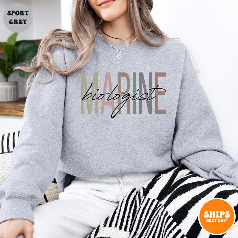a woman sitting on a couch wearing a grey sweatshirt