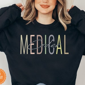 May include: Black sweatshirt with the text "MEDICAL Coder" in colorful, vertical letters.
