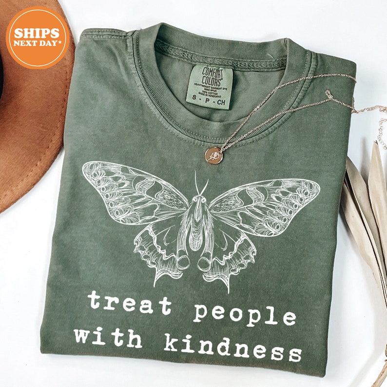a green t - shirt with a butterfly on it