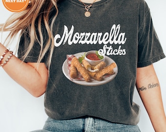 May include: A dark gray t-shirt with the text "Mozzarella Sticks" in white lettering. The shirt features a graphic of mozzarella sticks on a white plate with red dipping sauce.