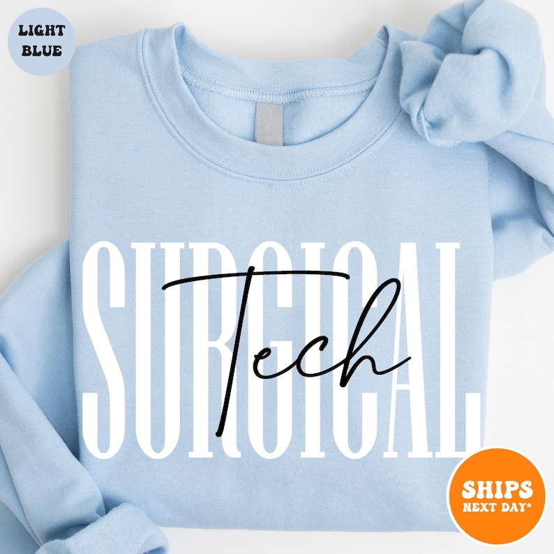 May include: Light blue sweatshirt with the text "SURGICAL Tech" in white and black lettering.