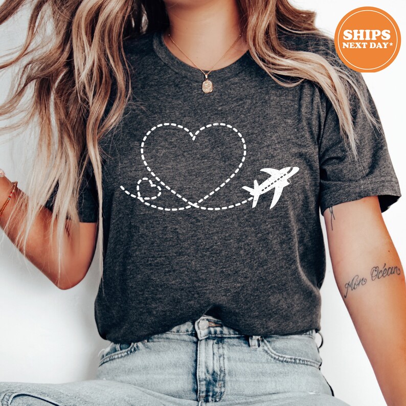 a woman wearing a t - shirt with a heart and airplane on it