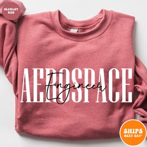 May include: A scarlet red sweatshirt with the text "Aerospace Engineer" in white lettering. The word "Engineer" is written in cursive.
