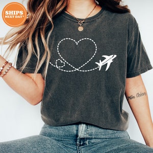 a woman wearing a t - shirt with a heart and airplane on it