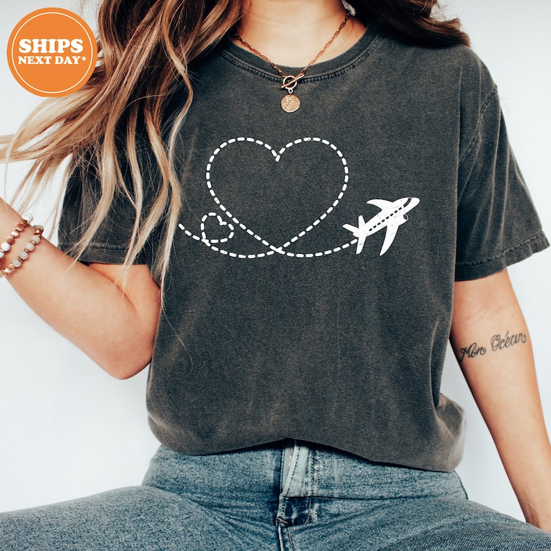 a woman wearing a t - shirt with a heart and airplane on it