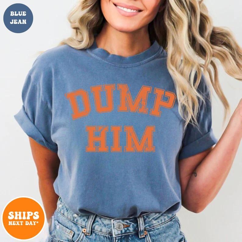 Pu&ograve; includere: Una t-shirt a maniche corte color blu jeans con la scritta DUMP HIM stampata in un audace carattere universitario arancione sul petto. La maglia presenta un girocollo, una vestibilit&agrave; rilassata e le maniche leggermente risvoltate ai bordi.