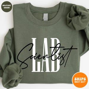 May include: A green sweatshirt with the text "LAB Scientist" in white and black lettering.