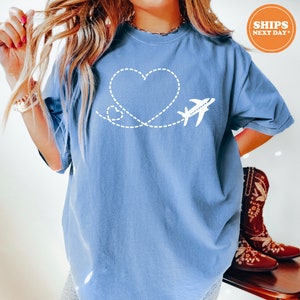a woman wearing a blue shirt with a heart and airplane on it