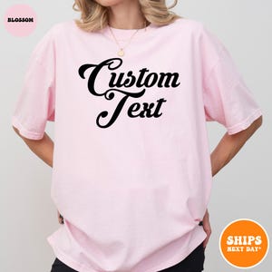 a woman wearing a pink shirt that says custom text
