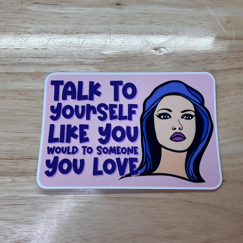 May include: A pink and white sticker with a blue-haired woman and the text "Talk to yourself like you would to someone you love."
