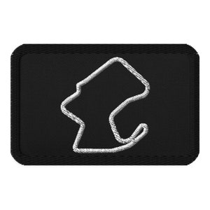 May include: A black embroidered patch with a white outline of a race track.