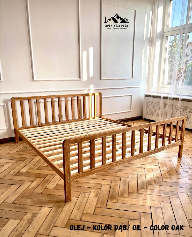 May include: A wooden bed frame with a slatted headboard and footboard, finished in an oak oil stain. The frame features vertical slats and a slatted base. Text on the image reads: HOLY-MOLYWOOD Family Carpentry Workshop and OLEJ - KOLOR DĄB / OIL - COLOR OAK.