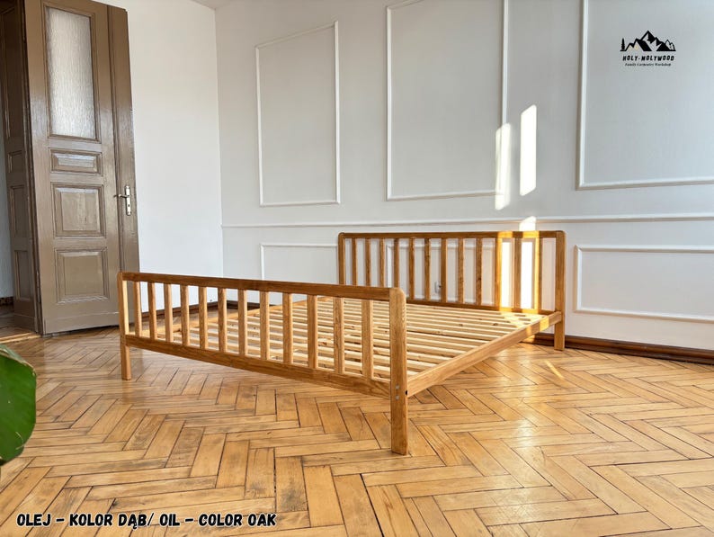 May include: A light brown oak bed frame with a slatted headboard and footboard. The wooden bed features a natural oil finish and a slatted base for mattress support. The frame is constructed with vertical wooden slats on all sides.