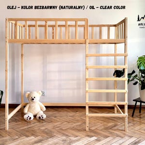 Peut inclure: Un lit mezzanine en bois naturel avec une échelle et des barrières de sécurité. Le cadre de lit est en bois clair et présente un design simple et minimaliste. Un ours en peluche est assis sur le sol sous le lit. Le texte en haut indique "OIL - CLEAR COLOR".