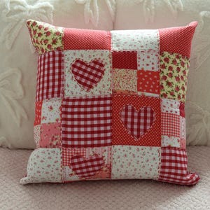 Handgjord kudde med rött hjärta och lapptäcke