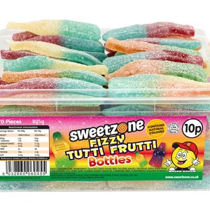 May include: A clear plastic container filled with colorful, fizzy Tutti Frutti gummy candies shaped like bottles. The candies are in various colors, including red, green, yellow, and orange. The container has a label with the brand name "Sweetzone".