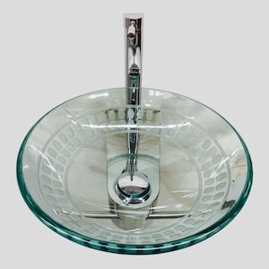 May include: A clear glass vessel sink with an etched pattern around the rim. The sink has a chrome faucet with a single handle.