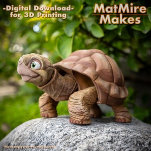 May include: A 3D printed model of a cartoon turtle with a brown shell and green eyes. The turtle is walking on a rock. The text "MatMire Makes" is in the top right corner of the image. The text "Digital Download - for 3D Printing" is in the top left corner of the image.