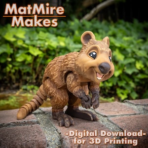 May include: A 3D printed model of a brown and tan quokka, a small marsupial native to Rottnest Island, Australia. The quokka is smiling and has a jointed tail. The model is posed standing on a brick surface. The text "MatMire Makes - Digital Download for 3D Printing" is visible below the quokka.