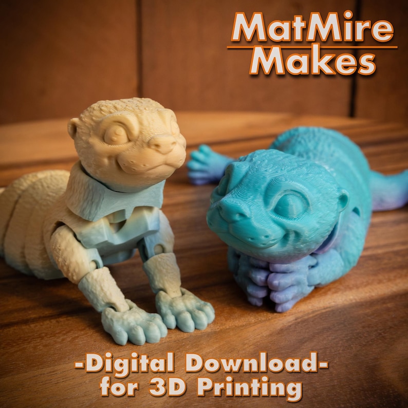 Pode incluir: Duas figurinhas de lontra articuladas impressas em 3D, uma em um esquema de cores azul claro e branco e a outra em um esquema de cores amarelo claro e azul. O texto "MatMire Makes - Digital Download - for 3D Printing" est&aacute; na parte superior da imagem.