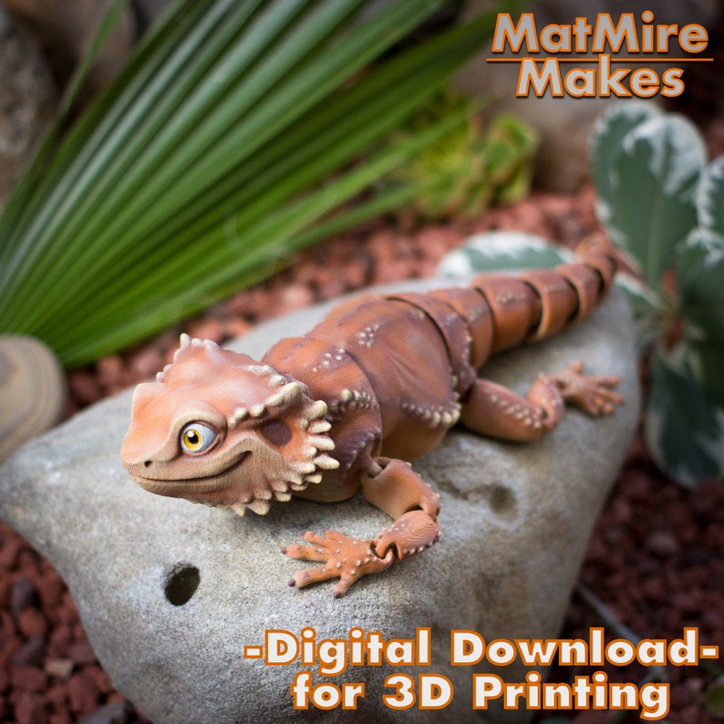 May include: A 3D printed model of a brown and orange lizard with articulated joints. The lizard is posed on a rock with a green plant in the background. The text "MatMire Makes - Digital Download - for 3D Printing" is printed on the image.